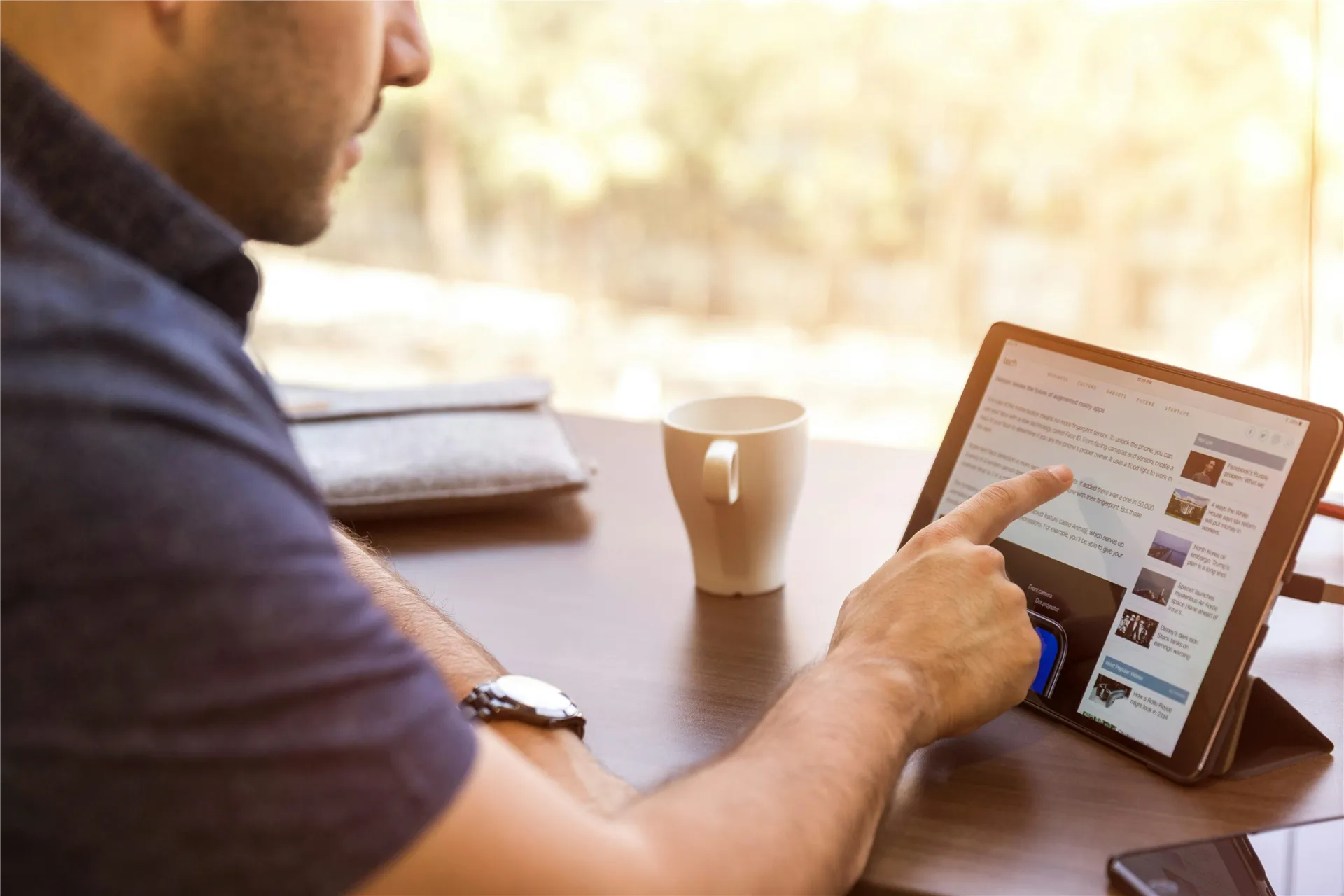 Man Using Ipad Sitting in Front of Desk